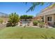 Lush backyard with artificial turf, mature trees, and inviting pool area at 10415 E Rosemary Ln, Scottsdale, AZ 85255