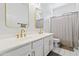 Bright bathroom featuring double sinks with gold fixtures, vanity, and a shower with neutral tones at 10415 E Rosemary Ln, Scottsdale, AZ 85255