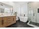 Bright bathroom featuring double sink vanity, free standing tub, and glass shower at 10415 E Rosemary Ln, Scottsdale, AZ 85255