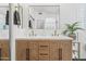 Bright bathroom featuring double vanity with gold fixtures and wood grain cabinets at 10415 E Rosemary Ln, Scottsdale, AZ 85255