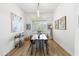 Bright dining room featuring hardwood floors, a modern light fixture, and seating for six at 10415 E Rosemary Ln, Scottsdale, AZ 85255