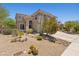Charming two-story home featuring desert landscaping with cactus and blooming bushes, a red tile roof, and an arched entryway at 10415 E Rosemary Ln, Scottsdale, AZ 85255