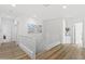Bright upstairs hallway featuring wood floors, white railings, and modern artwork at 10415 E Rosemary Ln, Scottsdale, AZ 85255