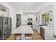 Modern kitchen featuring stainless steel appliances, white cabinets, an island with seating, and a tile backsplash at 10415 E Rosemary Ln, Scottsdale, AZ 85255