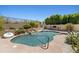 Sparkling private pool featuring a beautiful rock waterfall and lush desert landscaping at 10415 E Rosemary Ln, Scottsdale, AZ 85255