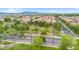 A neighborhood aerial view reveals a street with palm trees lining a park with mountain views in the distance at 1069 S Nancy Ln, Gilbert, AZ 85296