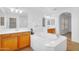Bathroom featuring a soaking tub, wood cabinets, and dual sinks at 1069 S Nancy Ln, Gilbert, AZ 85296