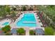 Aerial view of a large community pool surrounded by palm trees and lounge chairs at 1069 S Nancy Ln, Gilbert, AZ 85296