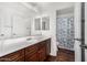 Well-lit bathroom with dark wood cabinetry, double mirrors, and a fish themed shower at 11580 N 145Th Ave, Surprise, AZ 85379