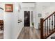 Inviting foyer with wood flooring, white walls, staircase, and a dark wood front door at 11580 N 145Th Ave, Surprise, AZ 85379