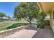 Exterior view of backyard with a patio and large mature trees on a sunny day at 13631 N 103Rd Ave, Sun City, AZ 85351