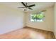 Neutral bedroom with laminate floors, ceiling fan, and large window overlooking the backyard at 13631 N 103Rd Ave, Sun City, AZ 85351