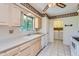 Traditional kitchen featuring light-colored cabinets, a double basin sink, and view into laundry room at 13631 N 103Rd Ave, Sun City, AZ 85351