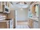 Kitchen featuring white appliances, light-colored cabinets and view into the living room at 13631 N 103Rd Ave, Sun City, AZ 85351