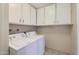 Laundry room featuring a side-by-side washer and dryer and lots of storage cabinets at 13631 N 103Rd Ave, Sun City, AZ 85351