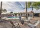 Backyard with a pool, gravel area, fire pit with seating, and lush landscaping for outdoor relaxation at 15841 N 23Rd Pl, Phoenix, AZ 85022