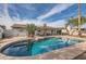 Backyard pool, surrounded by palm trees, a covered patio, and ample space for outdoor activities at 15841 N 23Rd Pl, Phoenix, AZ 85022