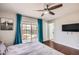 Bright bedroom featuring hardwood floors, ceiling fan, and sliding glass doors to the pool at 15841 N 23Rd Pl, Phoenix, AZ 85022