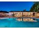 Nighttime view of the pool and backyard, highlighting the string lights, covered patio, and outdoor dining area at 15841 N 23Rd Pl, Phoenix, AZ 85022