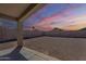 Spacious backyard area with gravel, concrete patio, block fence, and covered patio at 16077 W Larkspur Dr, Goodyear, AZ 85338