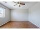 Bright bedroom featuring laminate flooring, a ceiling fan, and a large window for natural light at 16077 W Larkspur Dr, Goodyear, AZ 85338