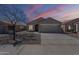 Charming single story home with desert landscaping, a two car garage, and lovely sunset sky at 16077 W Larkspur Dr, Goodyear, AZ 85338