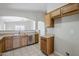 A bright kitchen featuring wood cabinetry, stainless steel appliances, and tiled floors at 16077 W Larkspur Dr, Goodyear, AZ 85338