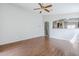 Open-concept living room with wood floors, ceiling fan, and a view into the kitchen area at 16077 W Larkspur Dr, Goodyear, AZ 85338