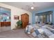 Inviting bedroom features bright blue accent wall, a wooden armoire, and comfortable furniture at 16527 W Blackhawk Ct, Surprise, AZ 85374