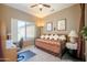 Cozy bedroom featuring a daybed, a ceiling fan, and large window offering nice natural light at 16527 W Blackhawk Ct, Surprise, AZ 85374