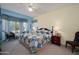 Comfortable bedroom with a patterned quilt, a bay window that lets in natural light, and cozy seating at 16527 W Blackhawk Ct, Surprise, AZ 85374