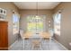 Bright dining room with a wooden table, four chairs, and abundant natural light from the window at 16527 W Blackhawk Ct, Surprise, AZ 85374