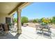 Relaxing covered patio featuring comfortable seating and a view of the manicured backyard at 16527 W Blackhawk Ct, Surprise, AZ 85374