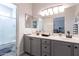Modern bathroom with dual sinks, sleek cabinets, and a spacious shower at 16536 W Rock Springs Ln, Surprise, AZ 85374