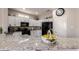 Modern kitchen with granite countertops and sleek, black appliances at 16536 W Rock Springs Ln, Surprise, AZ 85374