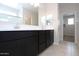 This bathroom features dual sinks, a large mirror, and tile flooring at 17419 W Via De Luna Dr, Surprise, AZ 85387
