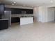 Bright kitchen featuring dark cabinets, a kitchen island, stainless steel appliances, and tile flooring at 17419 W Via De Luna Dr, Surprise, AZ 85387