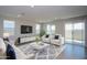 Open-concept living room with modern decor, large windows, and a sliding glass door for natural light at 17419 W Via De Luna Dr, Surprise, AZ 85387