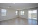 Bright and open living room with tile flooring, multiple windows, and a sliding glass door at 17419 W Via De Luna Dr, Surprise, AZ 85387