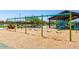 Community playground showcasing swings, a covered play structure, and landscaped surroundings at 17419 W Via De Luna Dr, Surprise, AZ 85387