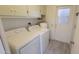 Practical laundry room featuring a washing machine, dryer, storage cabinets, and exterior access at 17463 N Del Webb Blvd, Sun City, AZ 85373