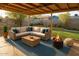 Cozy covered patio with an outdoor sofa, fire pit, and landscaped backyard, perfect for entertaining at 1914 W Colter St, Phoenix, AZ 85015