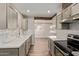 Modern kitchen with stainless steel appliances, white countertops, and stylish tiled backsplash at 2022 E Mulberry Dr, Phoenix, AZ 85016