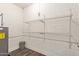 Utility room featuring exposed brick wall with two wire storage shelves at 2022 E Mulberry Dr, Phoenix, AZ 85016