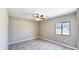 Neutral bedroom with a tile floor, ceiling fan, and bright window at 20427 W Mountain Sage Dr, Buckeye, AZ 85326