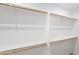 Walk-in closet with white walls and wood shelving perfect for storage and organization at 20427 W Mountain Sage Dr, Buckeye, AZ 85326