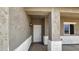 Inviting front porch with stucco accents, stylish lighting, and a white front door at 20427 W Mountain Sage Dr, Buckeye, AZ 85326
