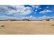 A sprawling home in a rural desert setting under a bright blue sky with puffy white clouds at 20427 W Mountain Sage Dr, Buckeye, AZ 85326