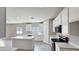 Modern kitchen with white cabinets, quartz countertops, and stainless steel appliances at 20427 W Mountain Sage Dr, Buckeye, AZ 85326