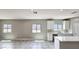 Modern kitchen with a center island and adjacent view of an airy living space with lots of natural light at 20427 W Mountain Sage Dr, Buckeye, AZ 85326